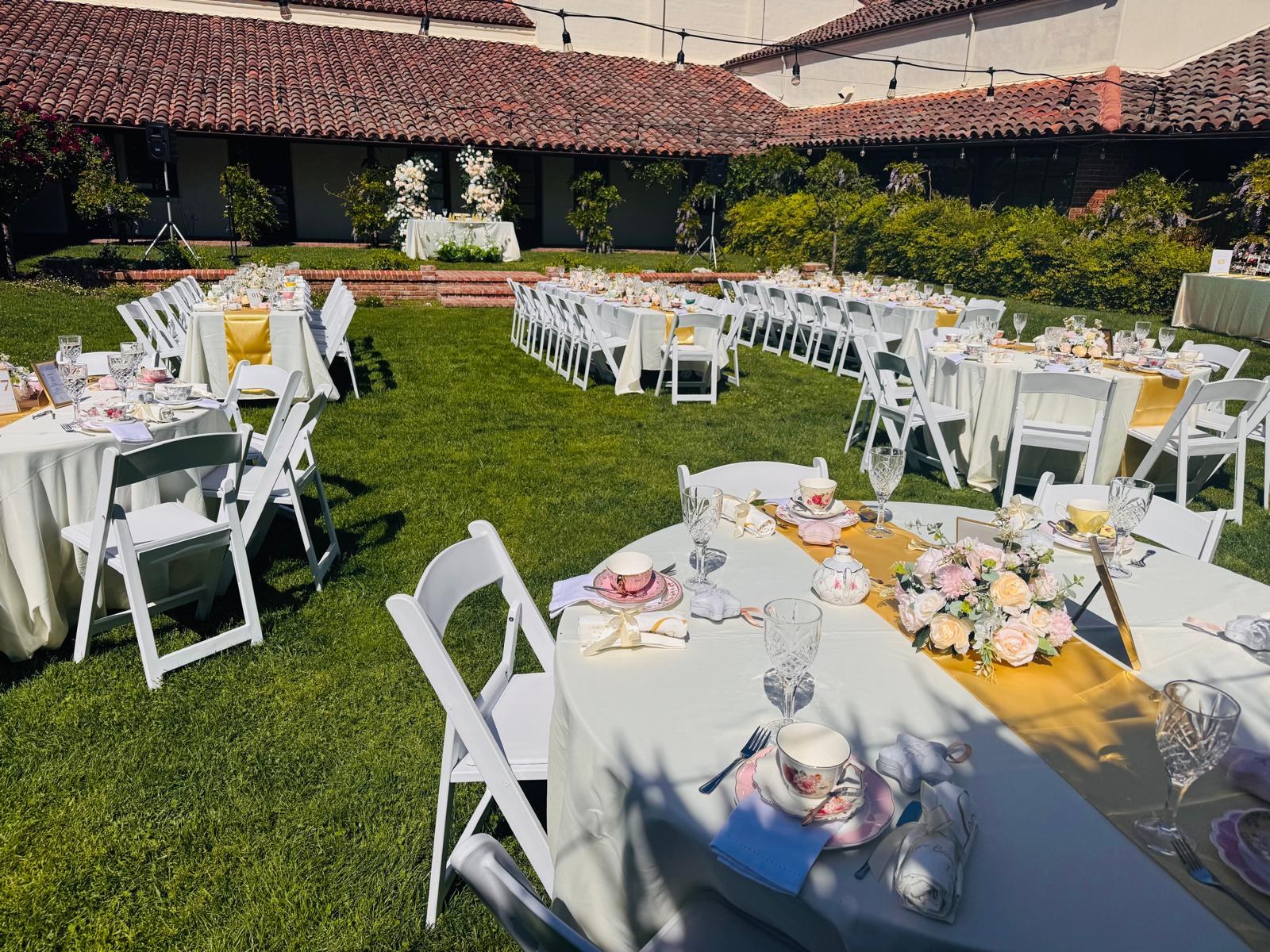 Large outdoor event styled with tea tables and floral decorations